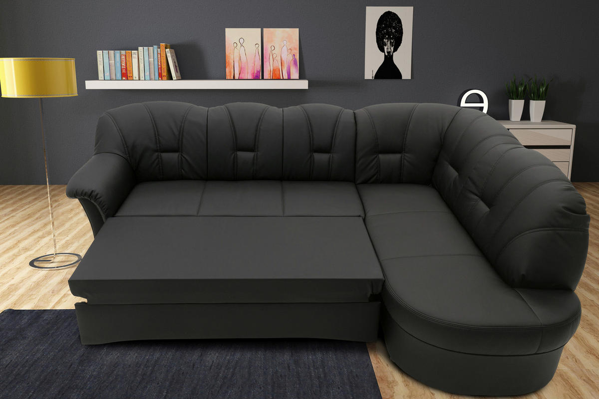 MID.YOU ECKSOFA Schwarz Lederlook, links davon: Lektüre, rechts davon: Nachttisch, Bild in schwarz, Topfpflanze in dunklem Wohnzimmer.
