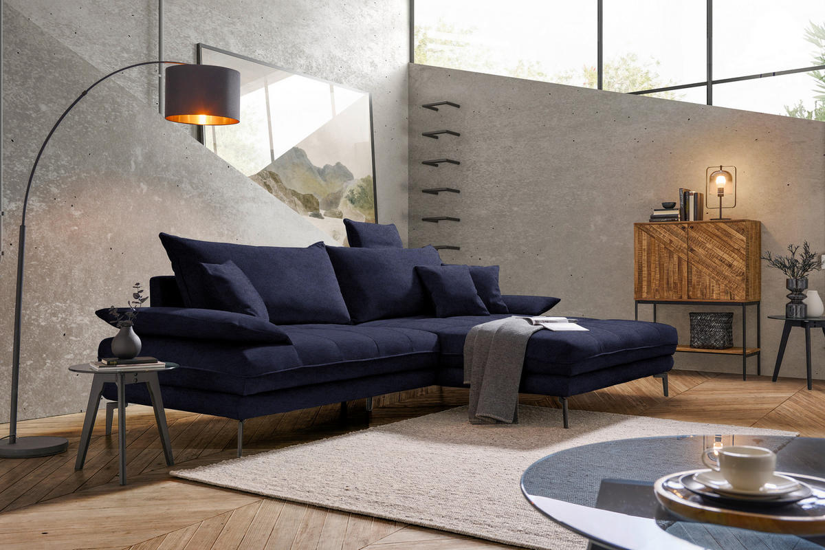 MID.YOU ECKSOFA PRATO Schwarz Flachgewebe, links davon: Lektüre, rechts davon: Hochflorteppich, Decke, Kissen in hellem Wohnzimmer.