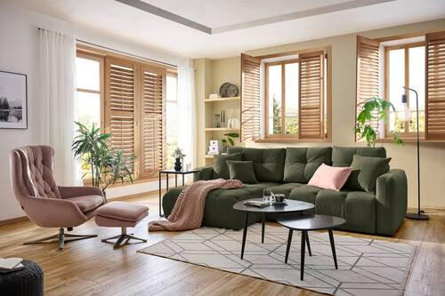 Hom`in ECKSOFA Dunkelgrün Chenille, links davon: Webteppich, Stuhl, Decke in grün, Topfpflanze in grün in hellem Wohnzimmer.