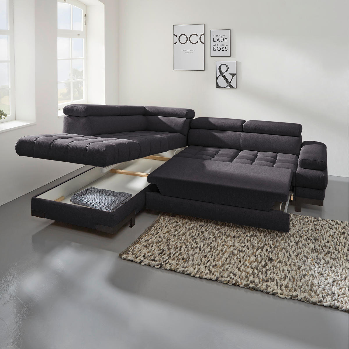 Welnova ECKSOFA Schwarz Webstoff, rechts davon: Hochflorteppich, Bild in hellem Wohnzimmer.