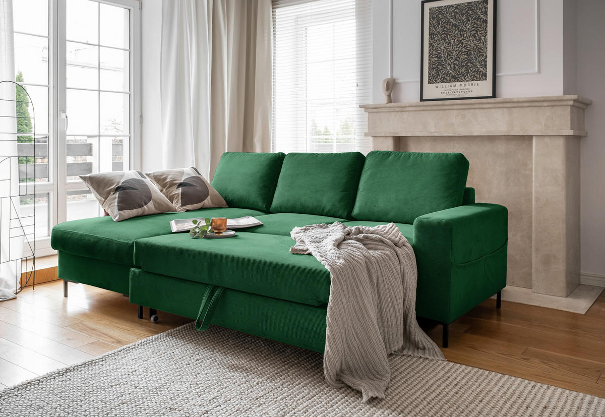 MID.YOU ECKSOFA Smaragdgrün Cord, links davon: Gardine in weiß, rechts davon: Webteppich, Decke, Bild in hellem Schlafzimmer.