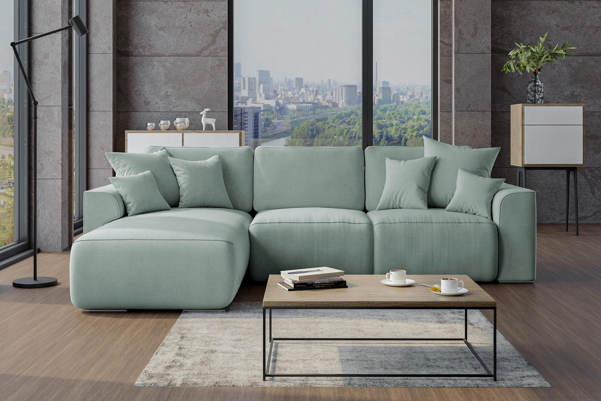 Carryhome ECKSOFA Mintgrün Velours, rechts davon: Couchtisch, Blume, Lektüre in schwarz in hellem Wohnzimmer.