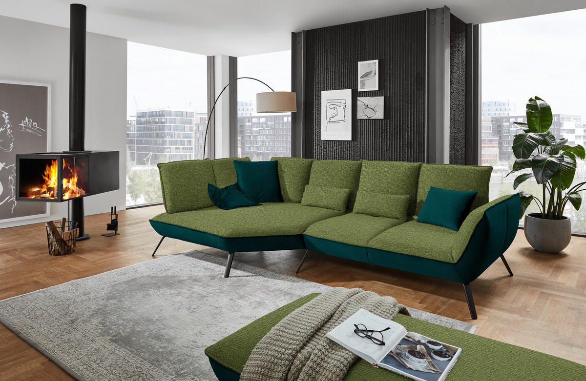 Moderano ECKSOFA Grün Flachgewebe, links davon: Hochflorteppich, rechts davon: Lektüre in weiß, Topfpflanze in grün, Kissen in grün in hellem Wohnzimmer.