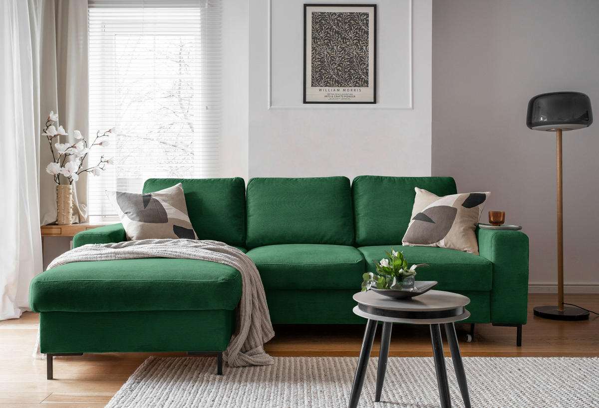 MID.YOU ECKSOFA Smaragdgrün Cord, links davon: Decke in grün, rechts davon: Hochflorteppich, Beistelltisch, Kissen in hellem Wohnzimmer.
