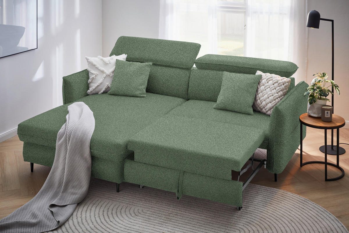 Stylife ECKSOFA Grün Flachgewebe, links davon: Webteppich, rechts davon: Store in grün, Beistelltisch, Kissen in hellem Wohnzimmer.