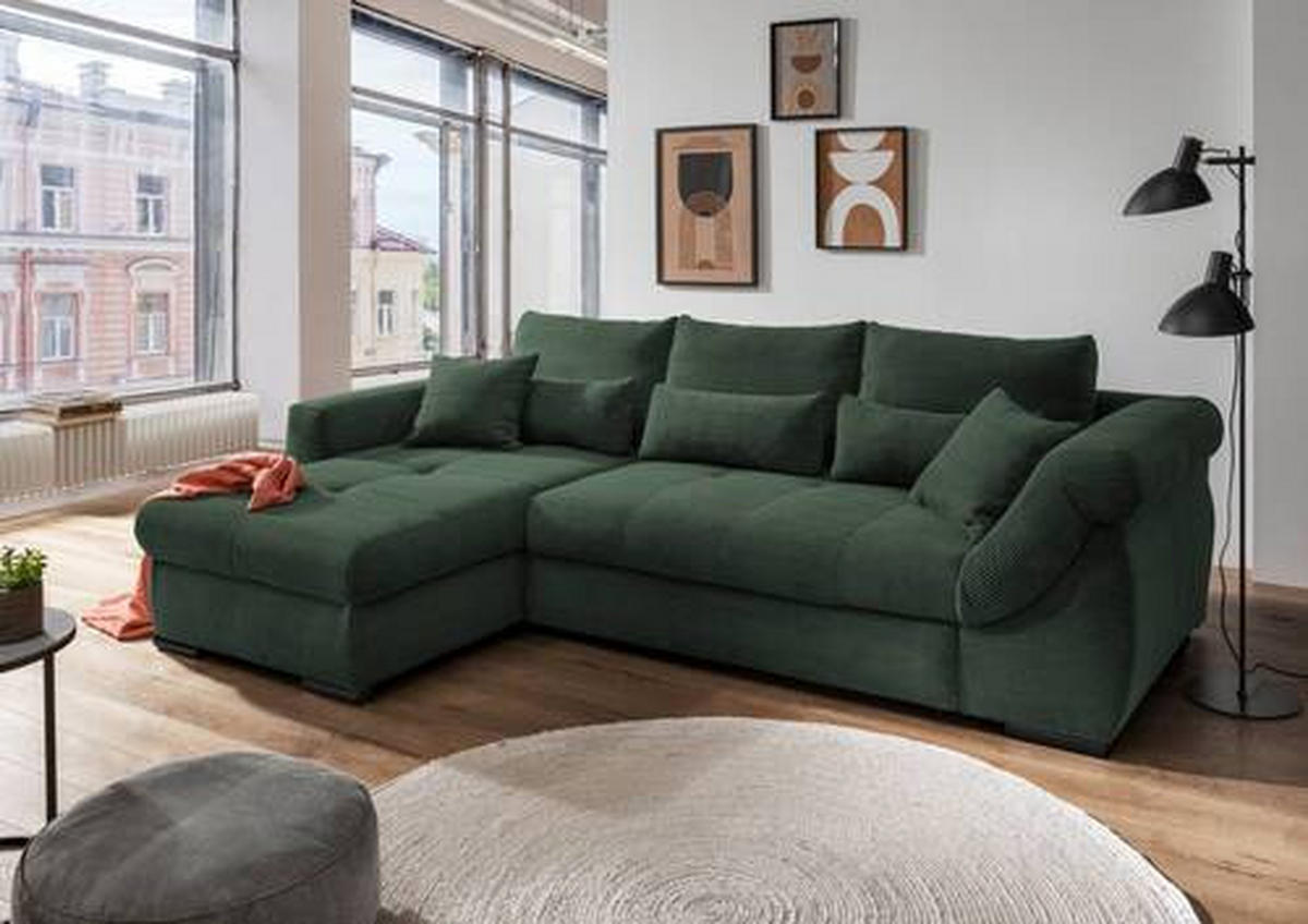 MID.YOU ECKSOFA Dunkelgrün Cord, links davon: Kissen in grün, Beistelltisch, rechts davon: Hochflorteppich in weiß, Bild in hellem Wohnzimmer.