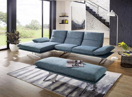 Koinor ECKSOFA Grün Flachgewebe, links davon: Hochflorteppich, Topfpflanze, rechts davon: Sitzbank, Beistelltisch in schwarz in hellem Wohnzimmer.