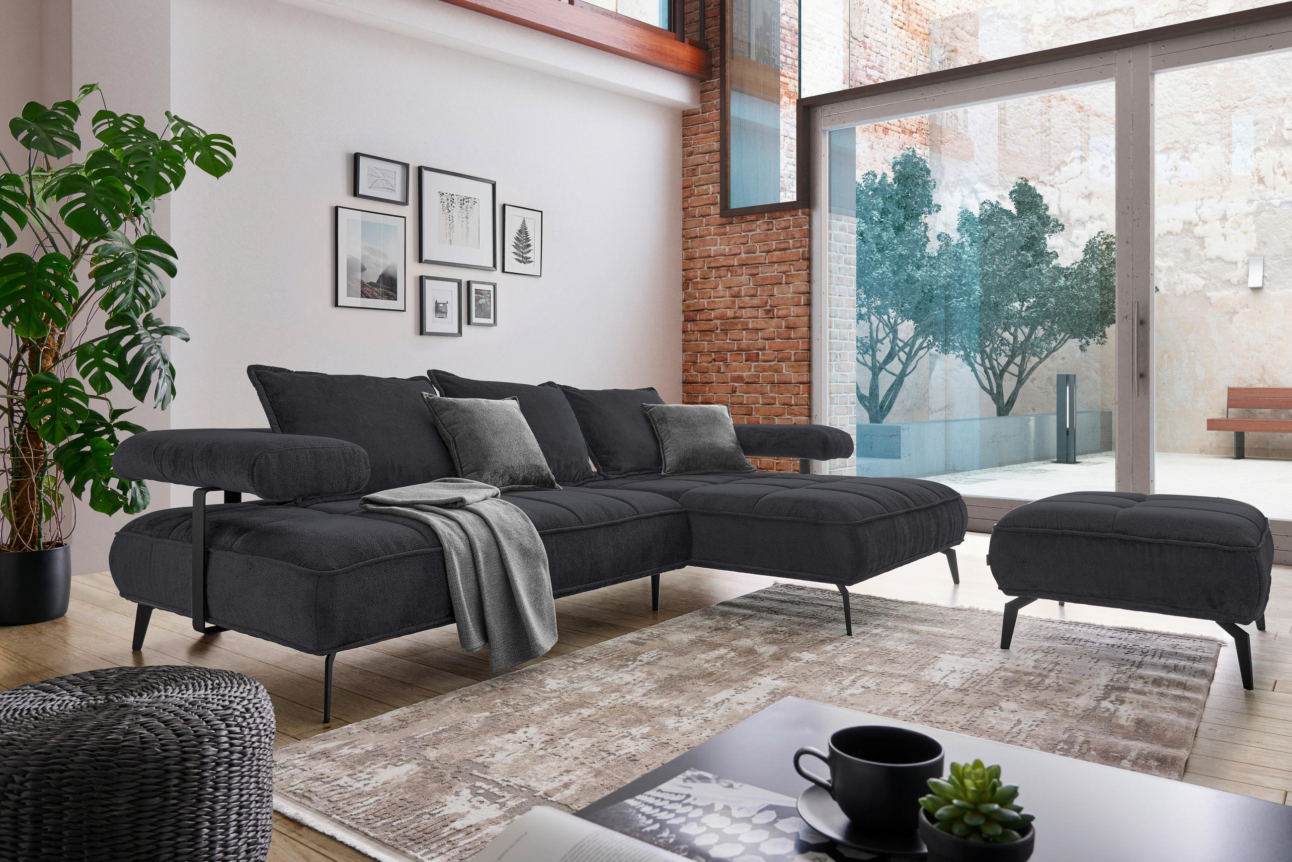 Welnova ECKSOFA Schwarz Webstoff, links davon: Topfpflanze in grün, Decke in grau, rechts davon: Hochflorteppich, Hocker in hellem Wohnzimmer.