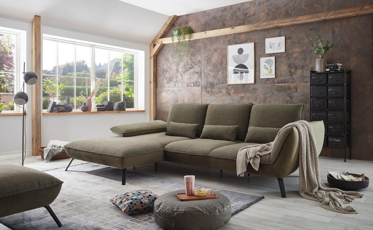 Moderano ECKSOFA Olivgrün Flachgewebe, links davon: Hochflorteppich, rechts davon: Highboard, Lektüre, Kissen in hellem Wohnzimmer.