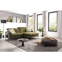 Dieter Knoll ECKSOFA Olivgrün Flachgewebe, links davon: Stehleuchte in schwarz, rechts davon: Webteppich, Decke, Hocker in schwarz in hellem Wohnzimmer.