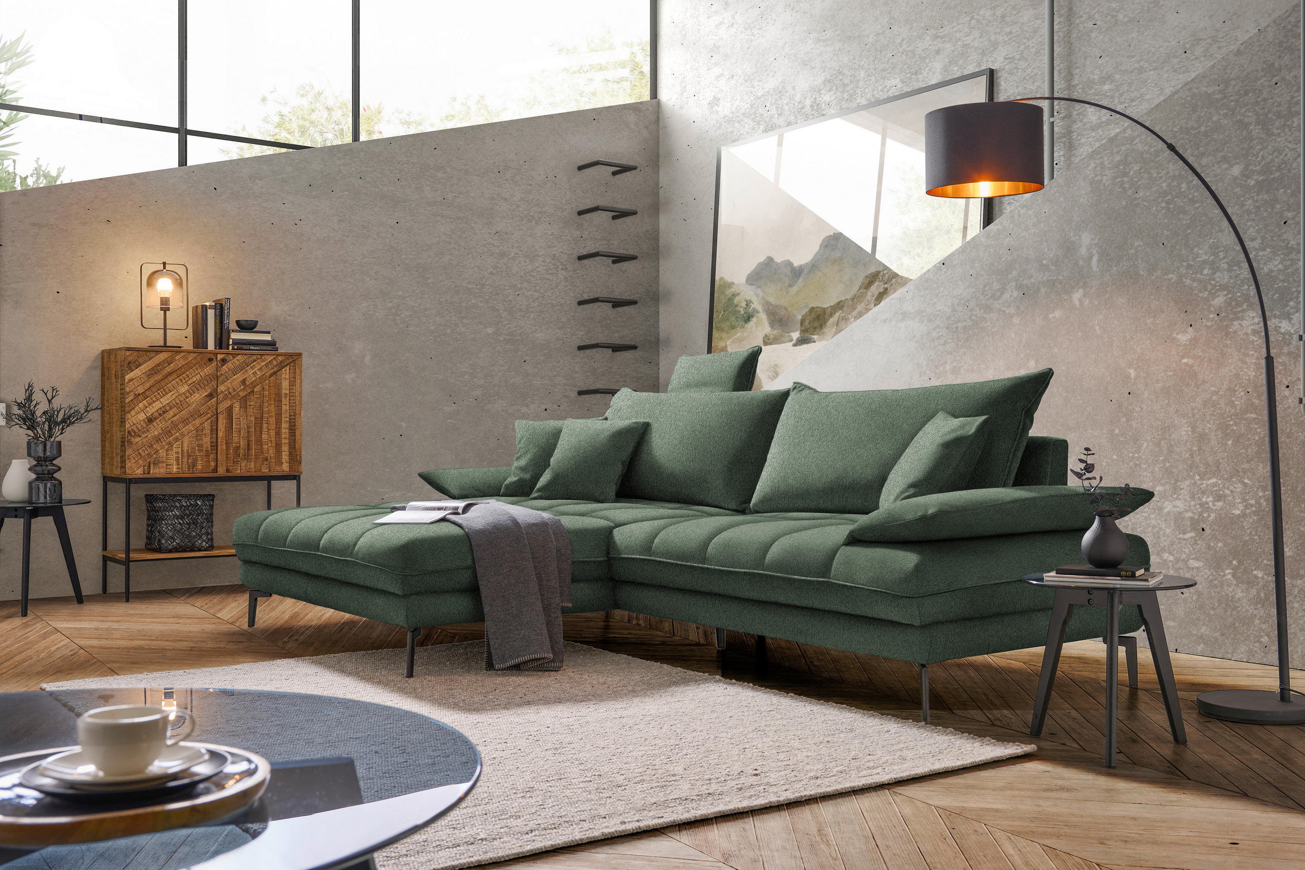 MID.YOU ECKSOFA PRATO Grün Webstoff, links davon: Hochflorteppich in weiß, Decke in grün, rechts davon: Beistelltisch, Kissen in grün in hellem Wohnzimmer.