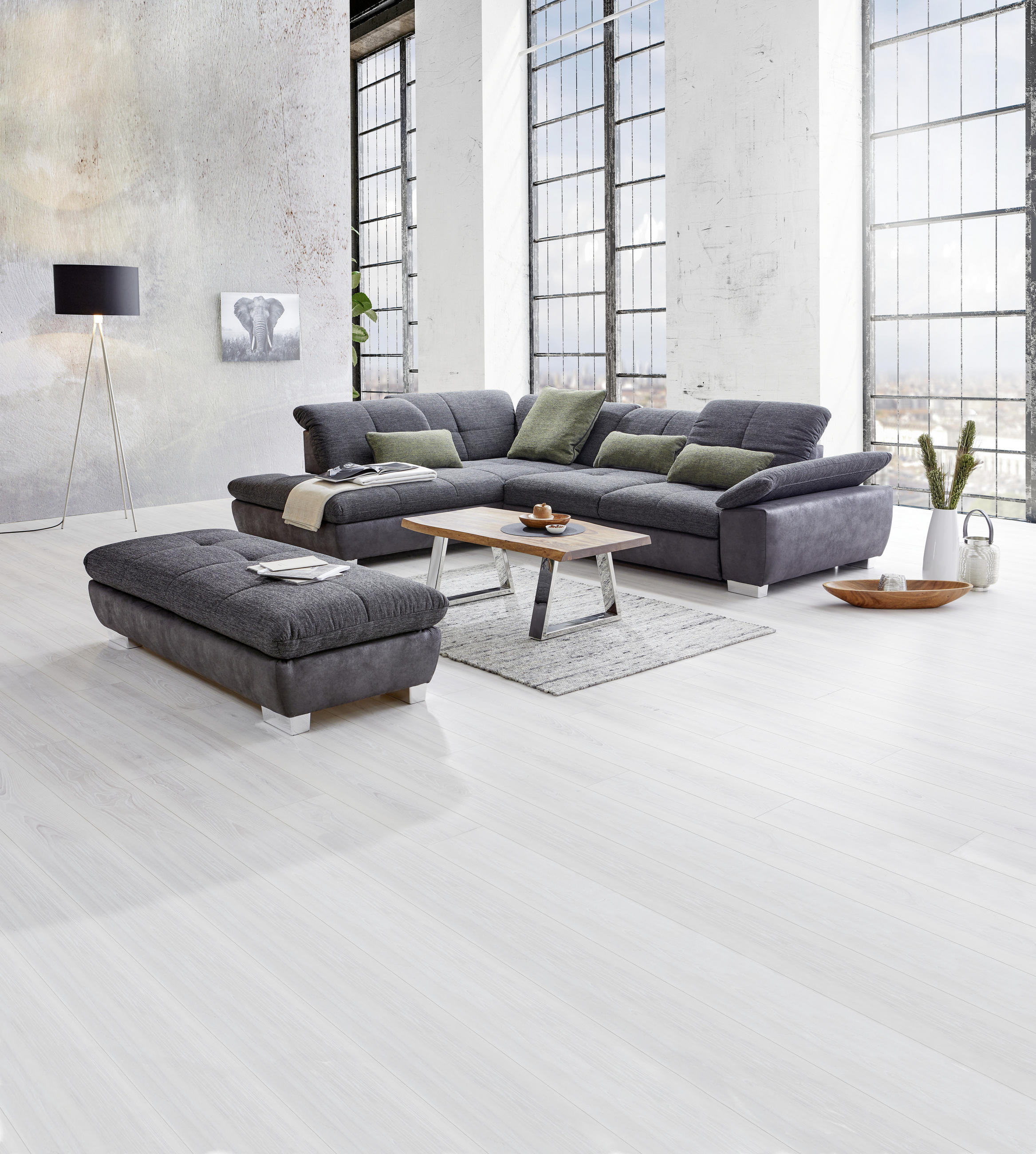 Xora ECKSOFA Schwarz Chenille, links davon: Hocker in grau, Lektüre, rechts davon: Hochflorteppich in grau, Couchtisch in grau in hellem Wohnzimmer.