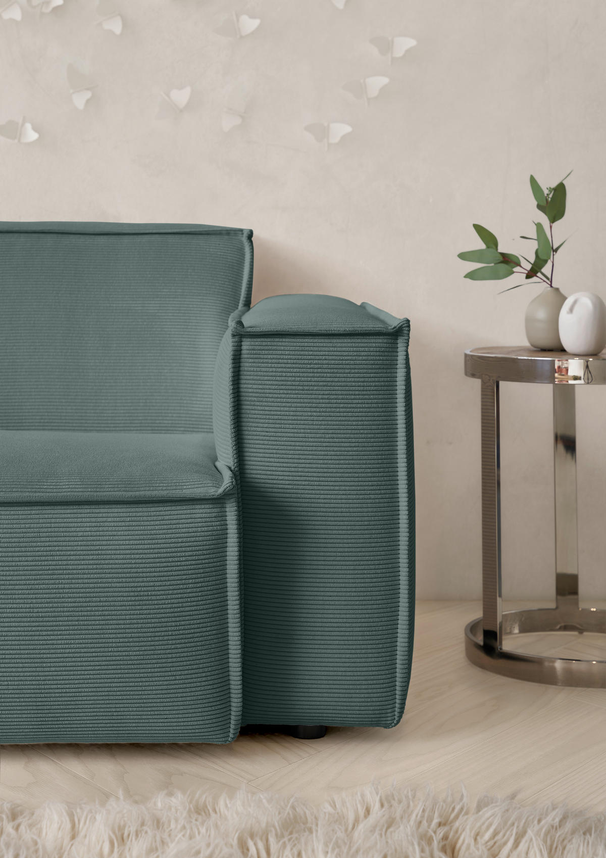 Hom`in Decke, rechts davon: Vase in weiß in hellem Wohnzimmer.