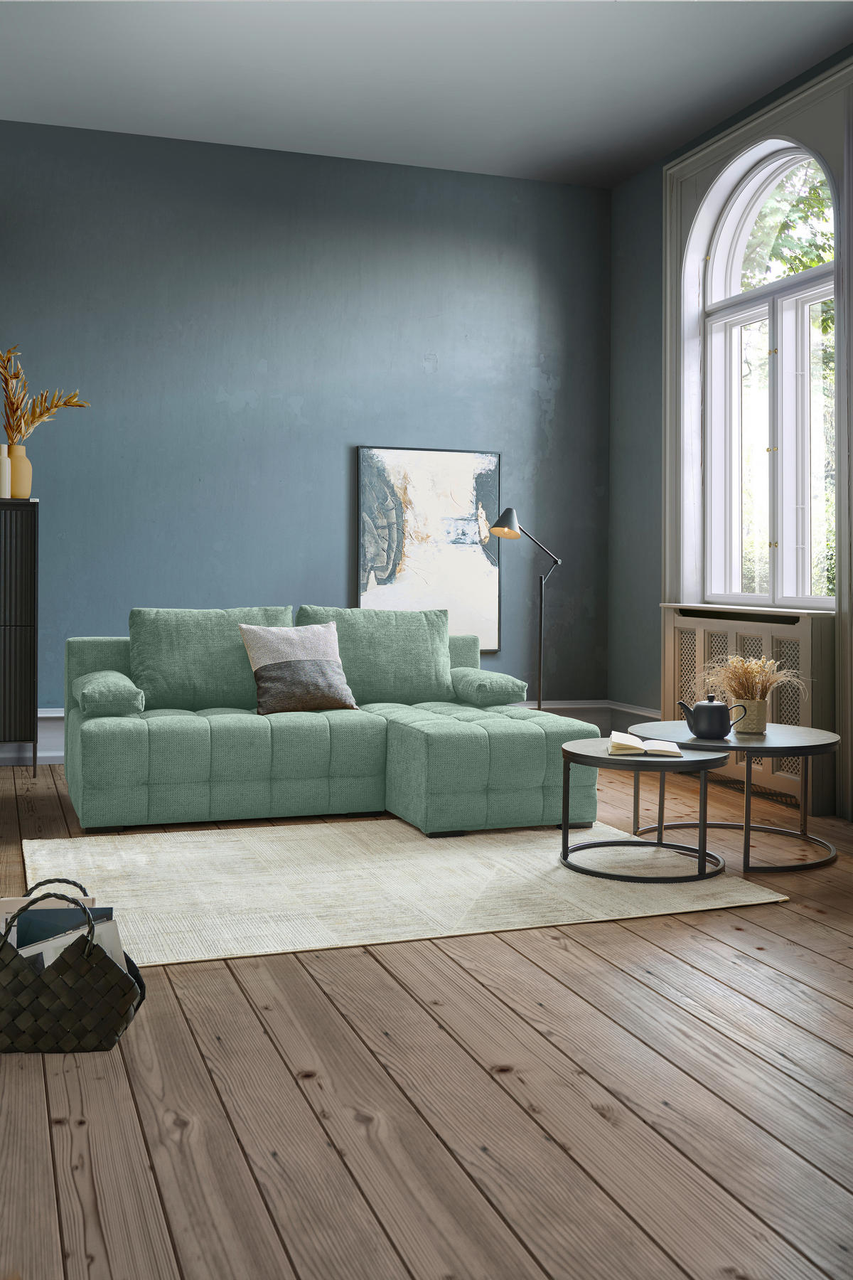 home24 ECKSOFA Dunkelgrün Chenille, rechts davon: Hochflorteppich, Couchtisch in schwarz, Bild in hellem Wohnzimmer.