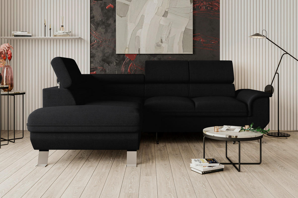 Carryhome ECKSOFA Schwarz Struktur, links davon: Beistelltisch, rechts davon: Store in schwarz, Lektüre in hellem Wohnzimmer.