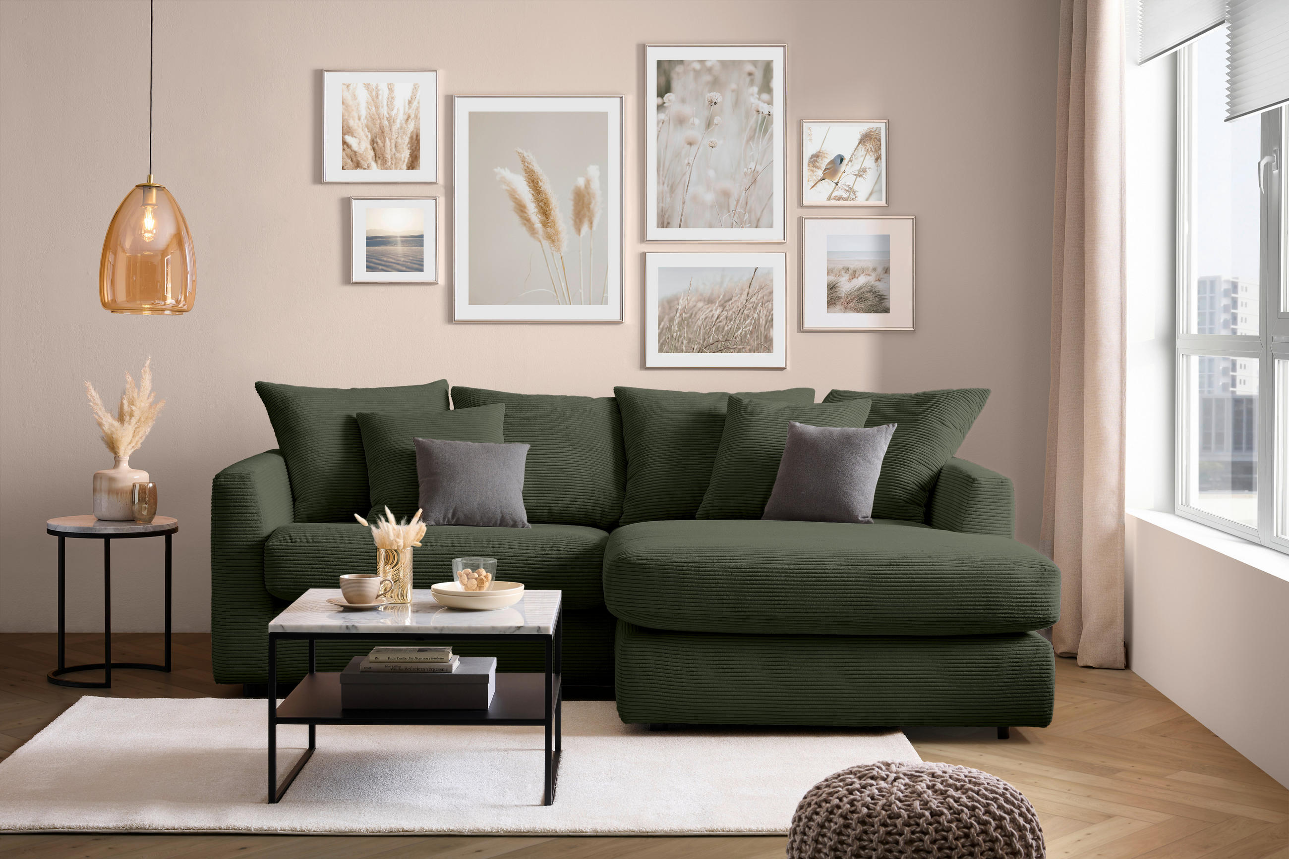 home24 ECKSOFA Dunkelgrün Cord, links davon: Hochflorteppich, Couchtisch, Beistelltisch, rechts davon: Regal in hellem Wohnzimmer.