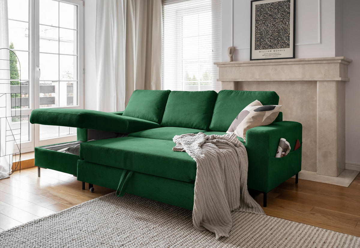 MID.YOU ECKSOFA Smaragdgrün Cord, links davon: Webteppich, Gardine, rechts davon: Decke, Jalousie in weiß in hellem Wohnzimmer.