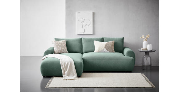 Carryhome ECKSOFA Grün Webstoff, links davon: Decke in grün, rechts davon: Hochflorteppich in weiß, Bild in weiß, Beistelltisch in hellem Wohnzimmer.