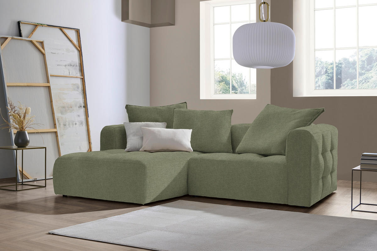 Stylife ECKSOFA MOSSO Grün Flachgewebe, links davon: Beistelltisch, rechts davon: Hochflorteppich in weiß, Deckenbeleuchtung, Store in weiß in hellem Wohnzimmer.