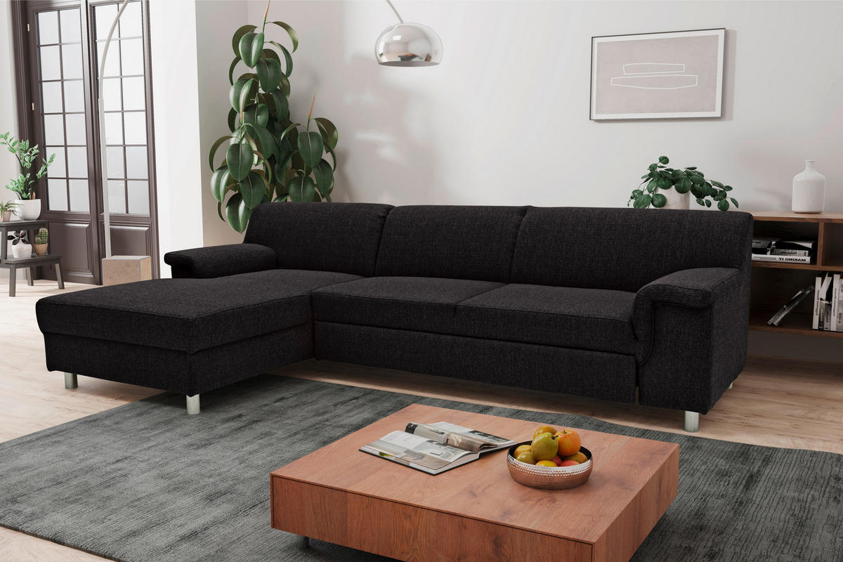 MID.YOU ECKSOFA Schwarz Webstoff, rechts davon: Hochflorteppich, Couchtisch, Lektüre in weiß, Bild in weiß in hellem Wohnzimmer.