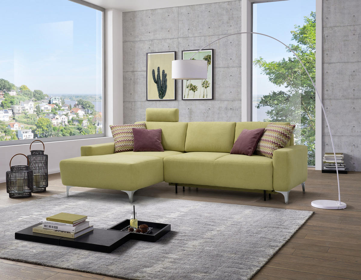 Sedda ECKSOFA Hellgrün Chenille, links davon: Hochflorteppich in grau, Lektüre, Kissen in lila, rechts davon: Bild in hellem Wohnzimmer.