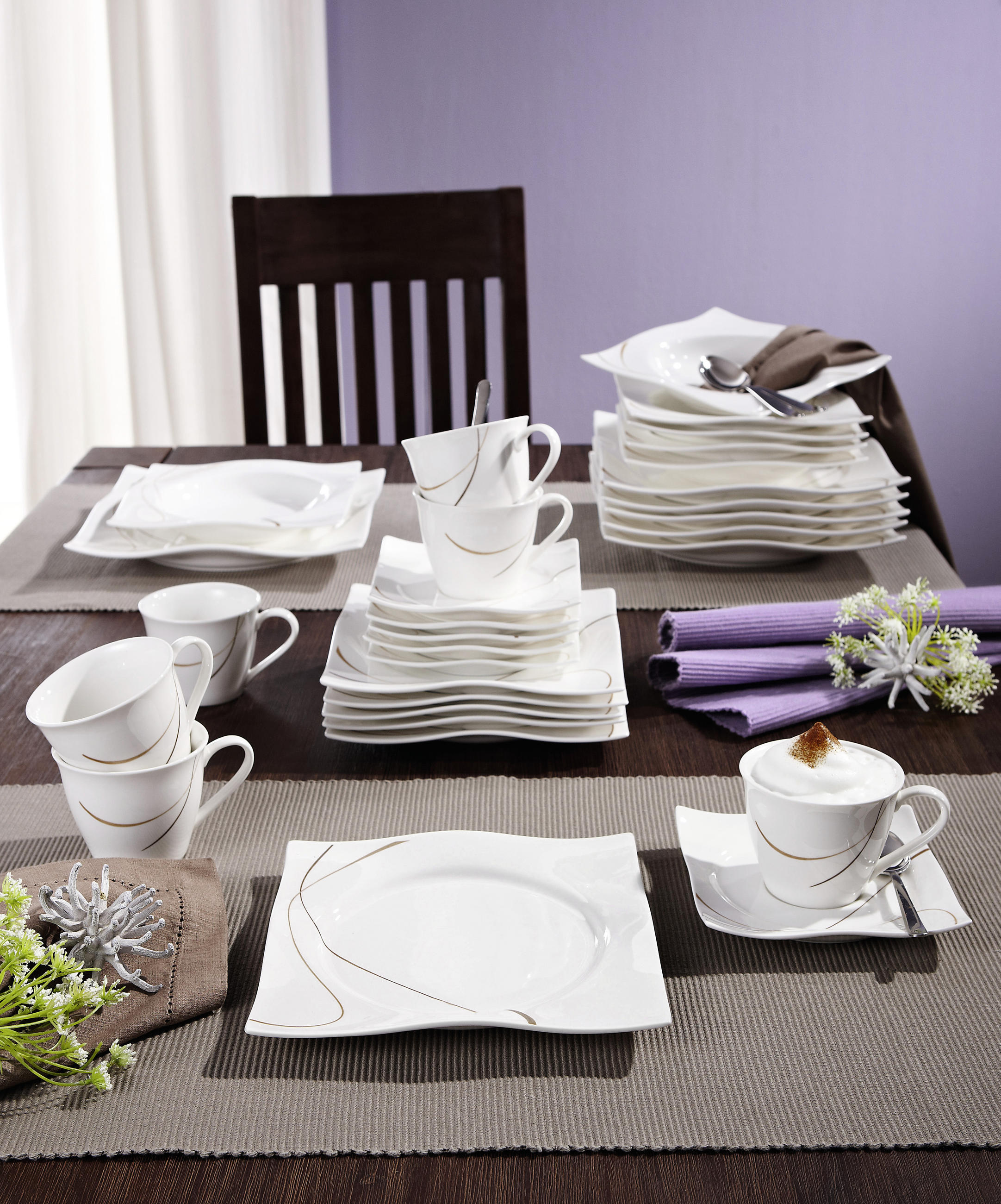 En kaffeservis som är tillverkad av porslin i naturligt vitt med 2 filigrana streck i brunt