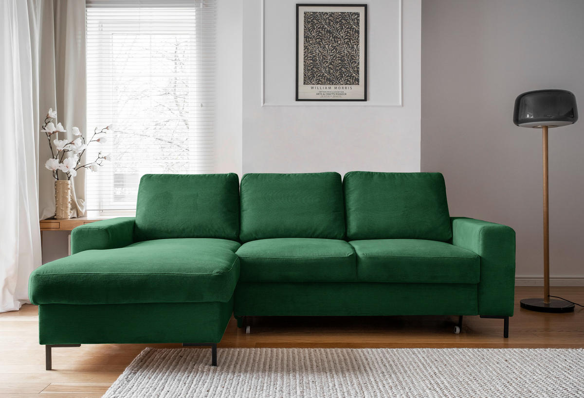 MID.YOU ECKSOFA Smaragdgrün Cord, links davon: Blume in weiß, rechts davon: Webteppich in weiß, Bild, Stehleuchte in hellem Wohnzimmer.