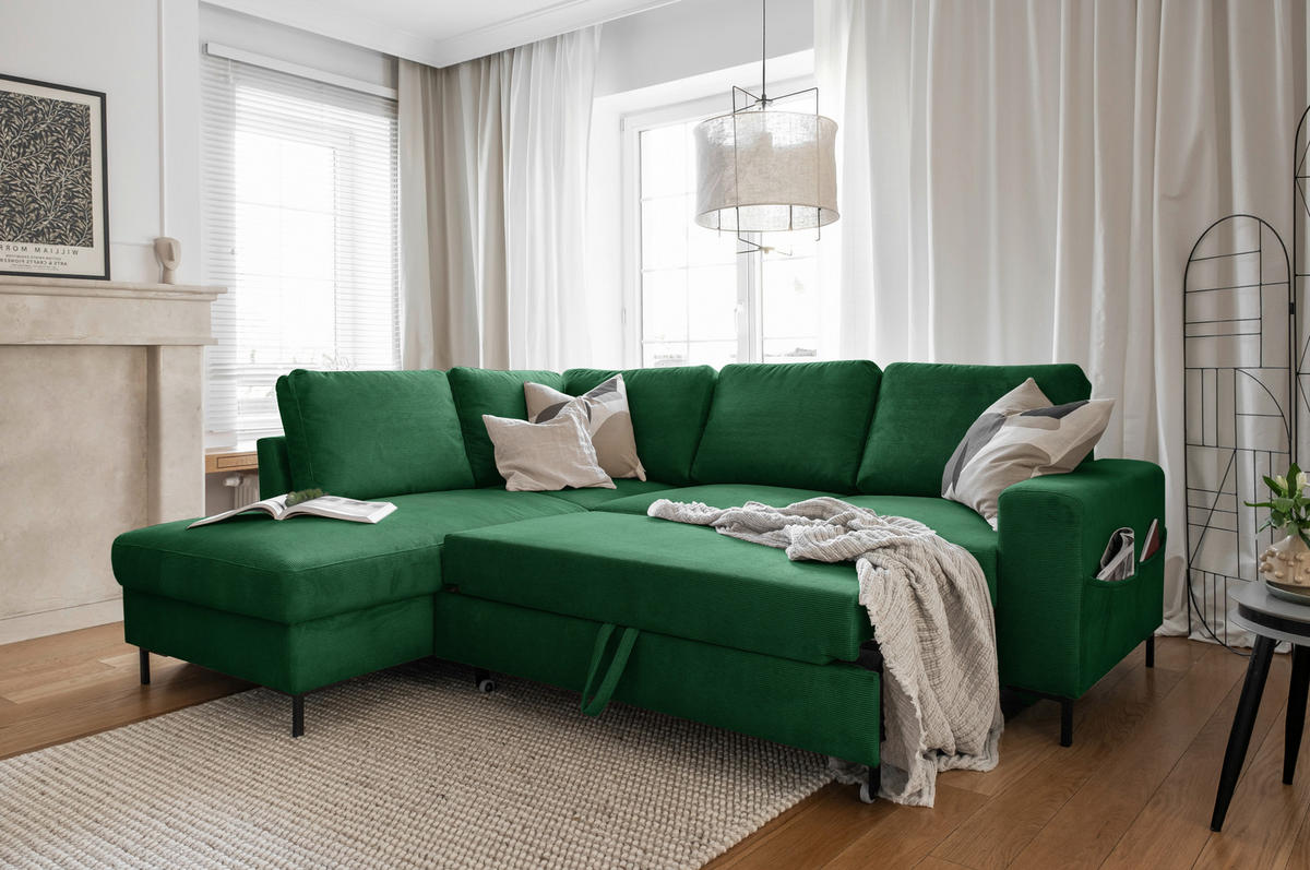 MID.YOU ECKSOFA Smaragdgrün Cord, links davon: Webteppich in grün, Lektüre, rechts davon: Decke in grün, Kissen in hellem Wohnzimmer.