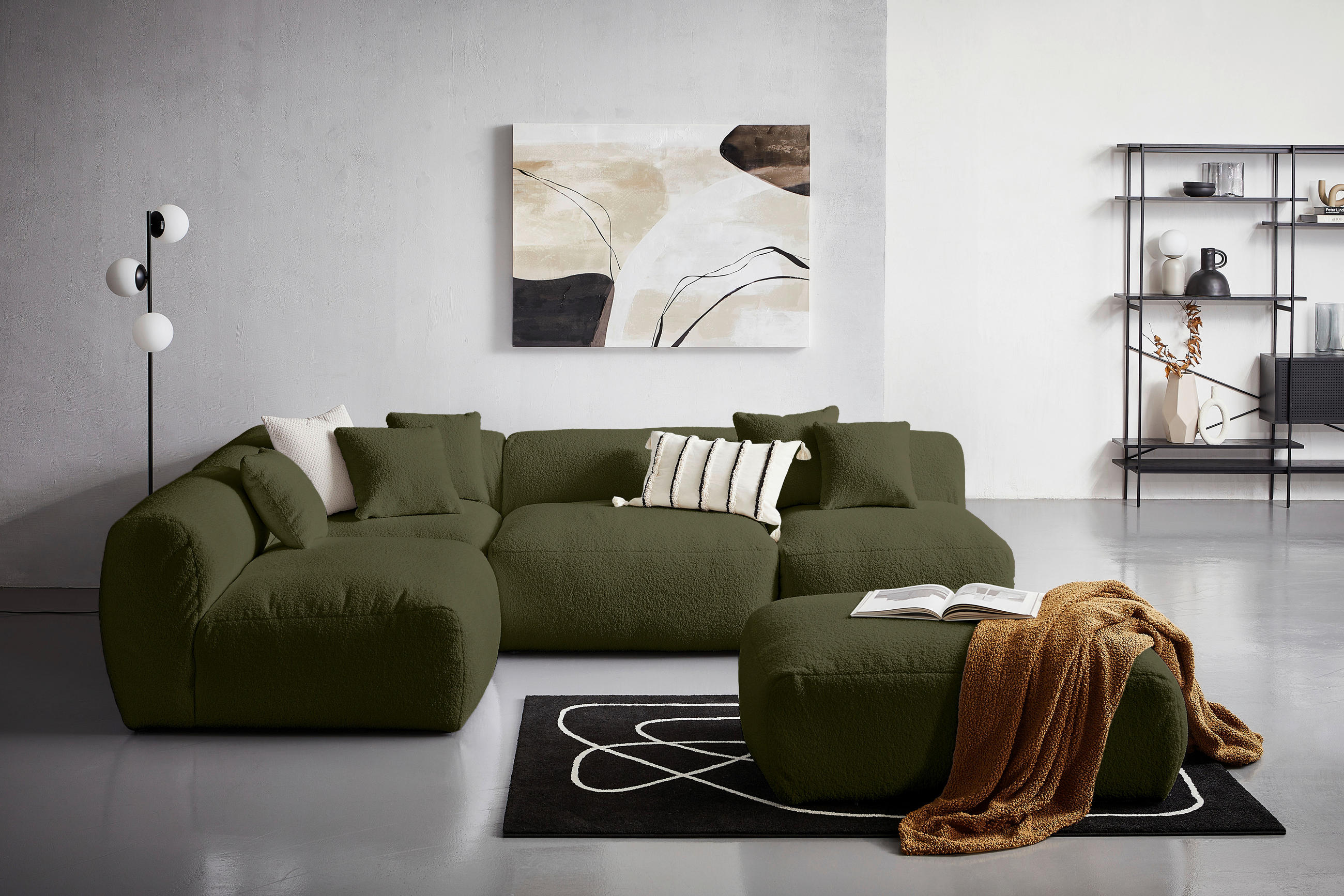 Livetastic ECKSOFA inkl. Hocker BLOOM Olivgrün Flachgewebe, Teddystoff, rechts davon: Decke, Regal in schwarz, Lektüre in weiß in hellem Wohnzimmer.