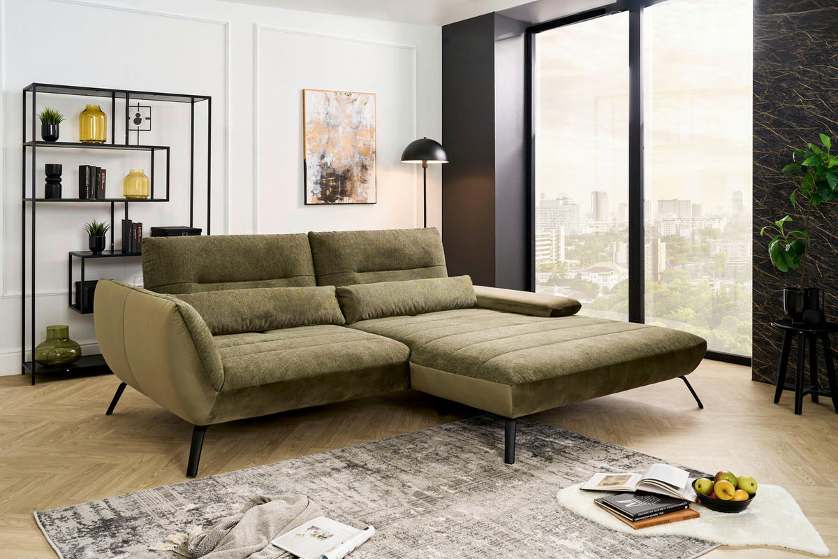 Carryhome ECKSOFA Olivgrün Webstoff, links davon: Webteppich, Regal, rechts davon: Bild, Deckenbeleuchtung in hellem Wohnzimmer.