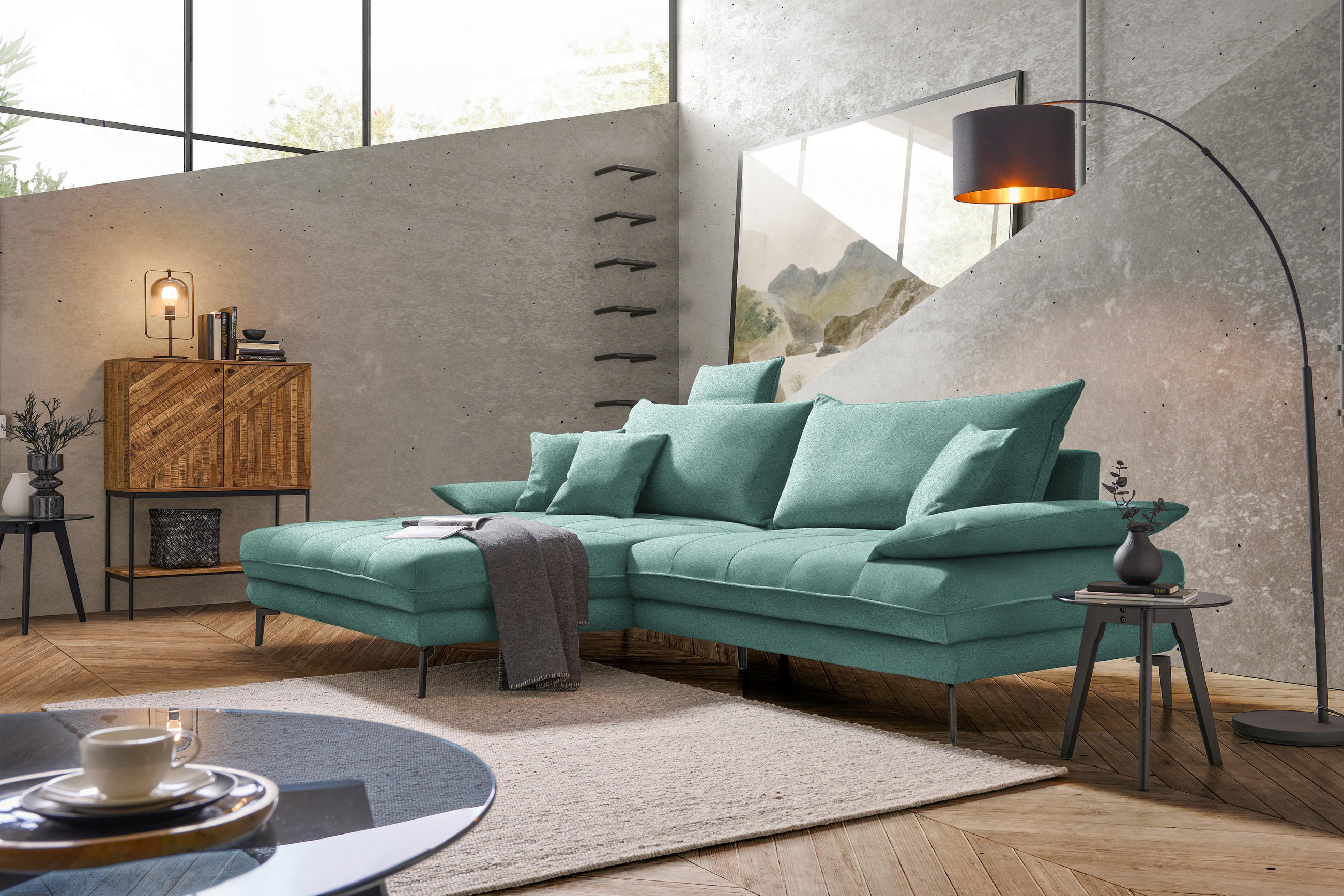 MID.YOU ECKSOFA PRATO Mintgrün Mikrofaser, links davon: Hochflorteppich in weiß, Decke in grün, rechts davon: Beistelltisch, Kissen in grün in hellem Wohnzimmer.