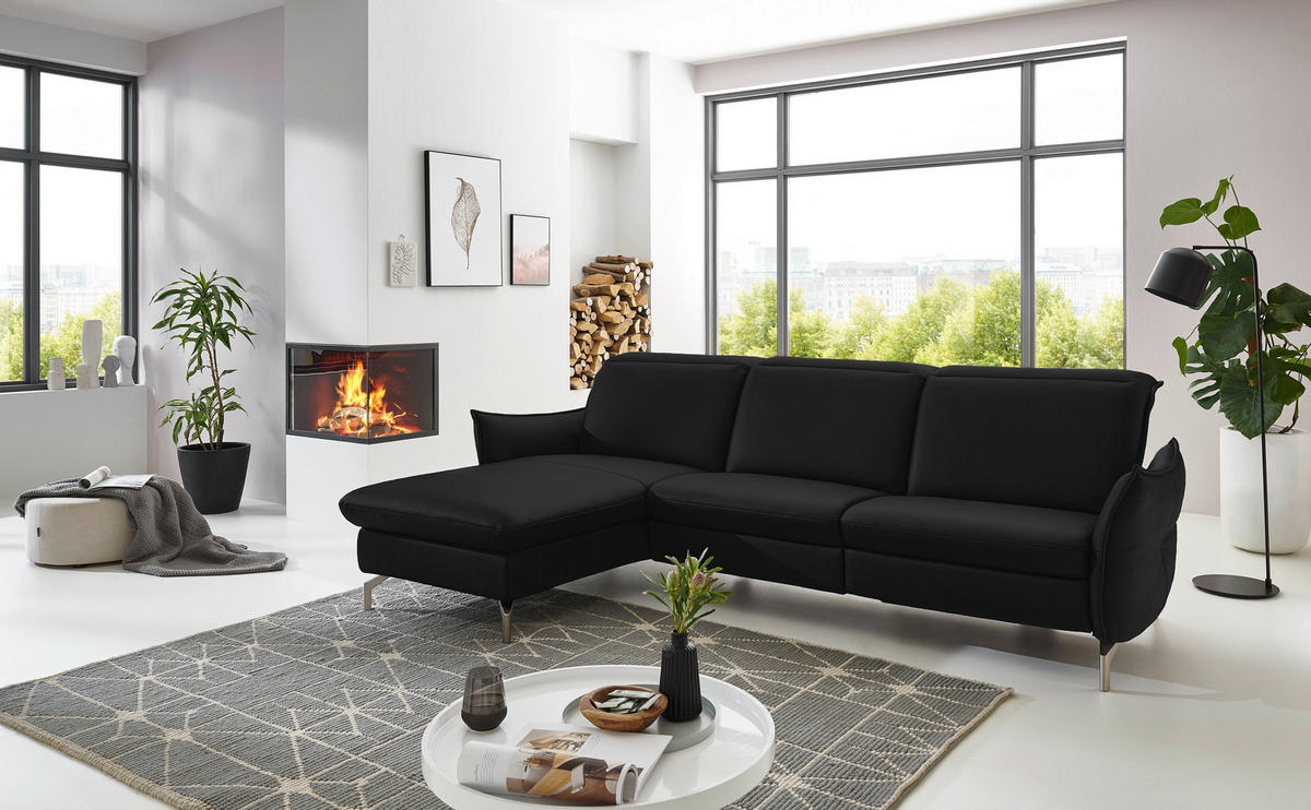 Livetastic ECKSOFA Schwarz Lederlook (vegan), links davon: Hochflorteppich, Couchtisch, Topfpflanze, Deckenbeleuchtung in weiß in hellem Wohnzimmer.