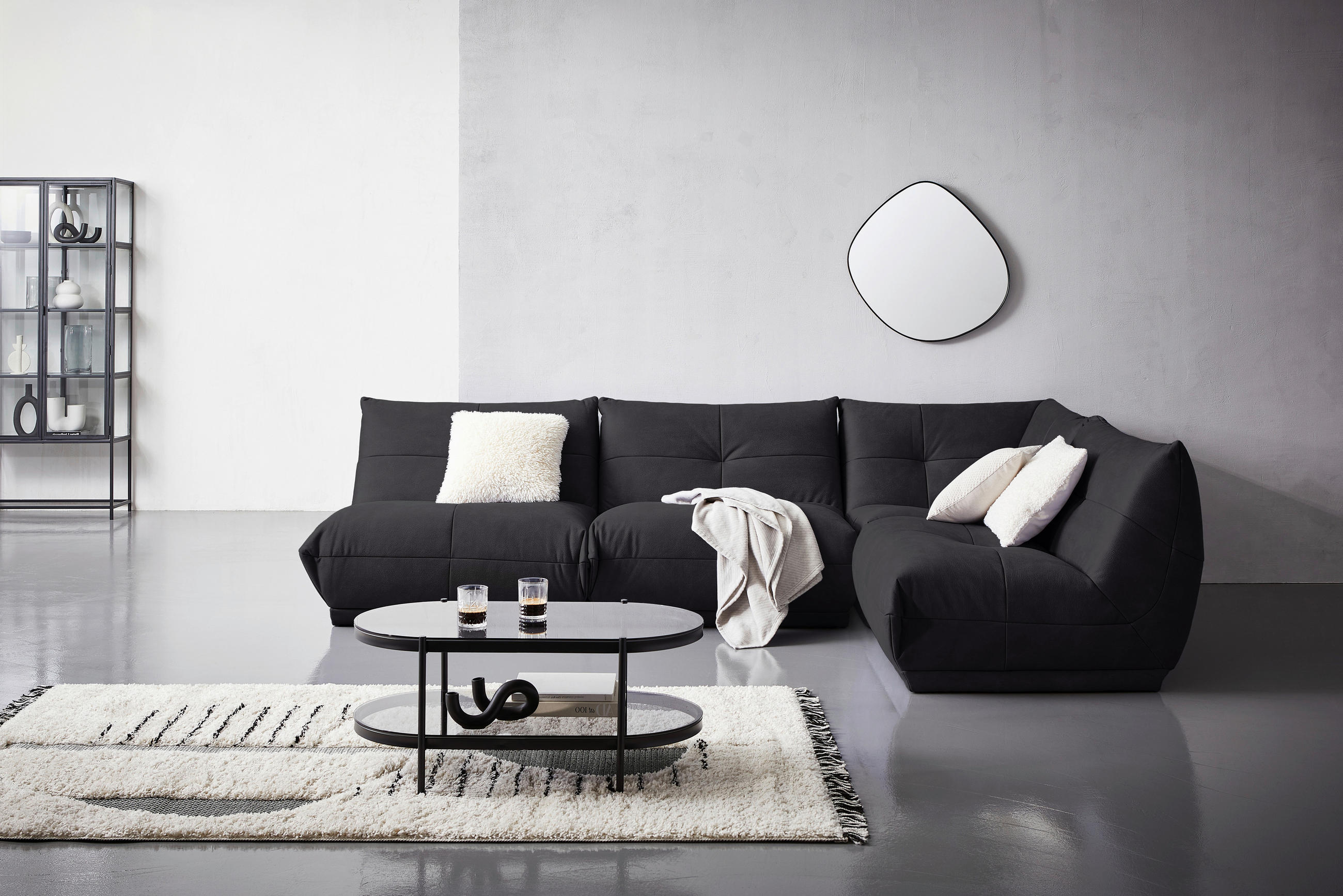 Livetastic ECKSOFA Schwarz Lederlook, links davon: Hochflorteppich in schwarz, Couchtisch in schwarz, rechts davon: Spiegel in weiß, Decke in weiß in hellem Wohnzimmer.